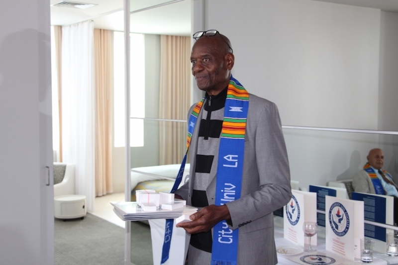University officer holding a stack of convocation programmes