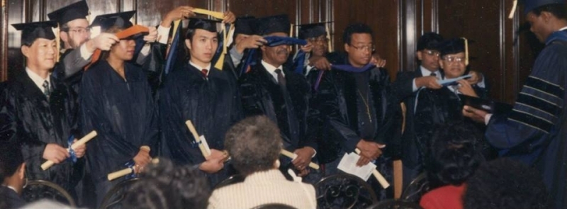 A line of graduates being hooded during the commencement ceremony
