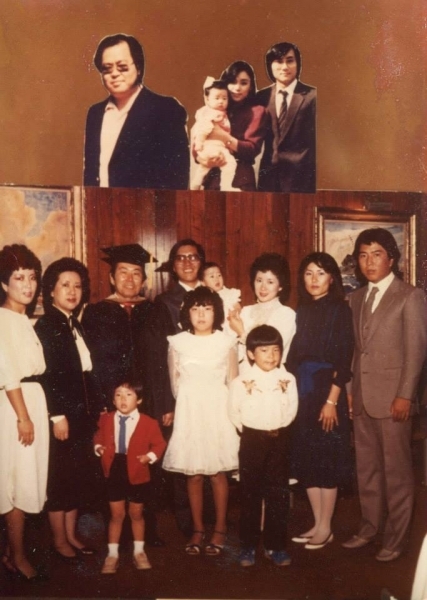 Extended family gathered for a portrait with a graduate in cap and gown