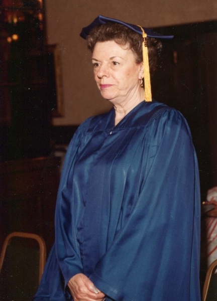 Graduate in blue regalia waiting to process into the ceremony