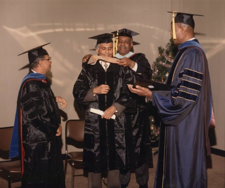 Faculty placing the doctoral hood on a graduate during a hooding ceremony
