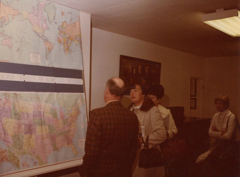 Visitors studying a world map display at the university offices