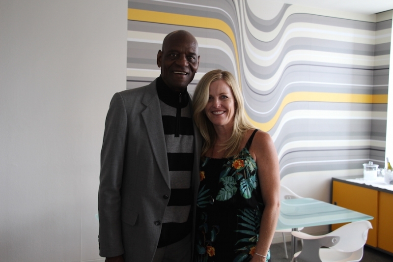 University leader standing with a guest in a modern reception room