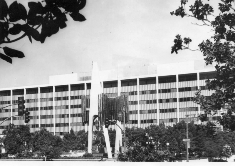 Mid-century modern university building with a sculpture at the entrance plaza