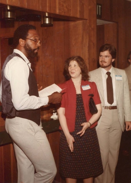 University staff member speaking with two prospective students at an information session
