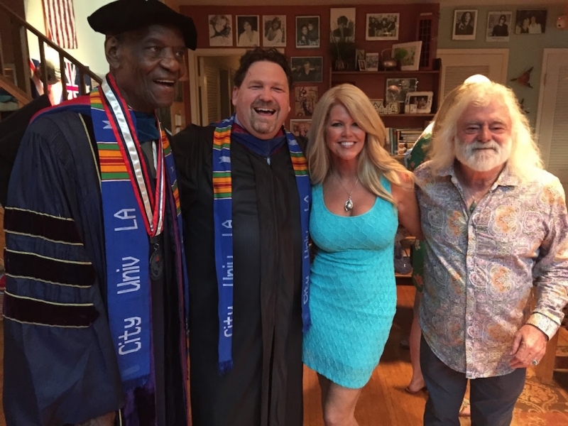 Faculty and guests laughing together at a celebration following a ceremony