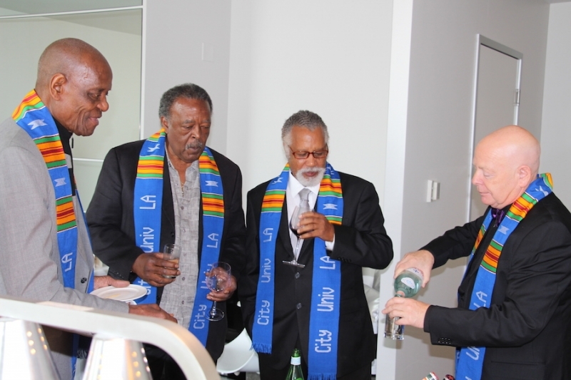 Guests in university stoles pouring drinks at a reception