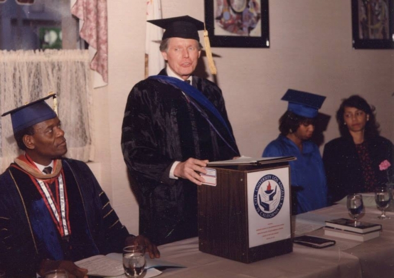 Faculty member in regalia speaking from a City University Los Angeles podium