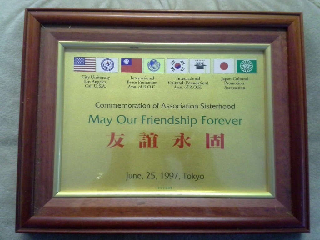 Framed gold plaque commemorating association sisterhood with international cultural and peace associations