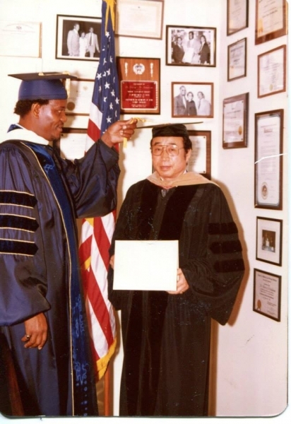 University officer turning the tassel of a doctoral honouree holding a certificate