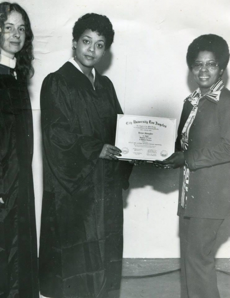 Graduate receiving a City University Los Angeles certificate from a presenter