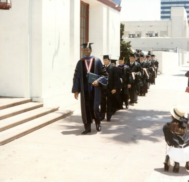 Faculty and graduates walking in academic procession outdoors in Los Angeles
