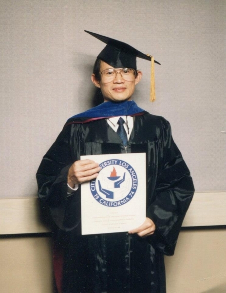 Graduate in cap and gown holding a City University Los Angeles diploma