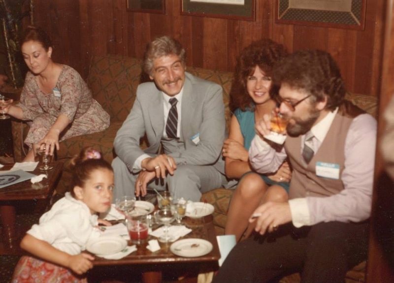 Guests and family seated in a wood-panelled lounge at a university reception