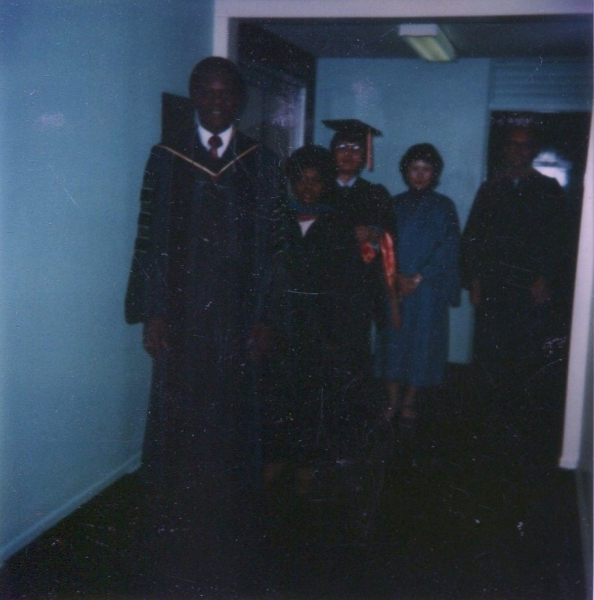Faculty member leading graduates and family through a corridor before the ceremony