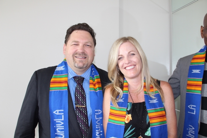 Two faculty members in university stoles smiling at a reception