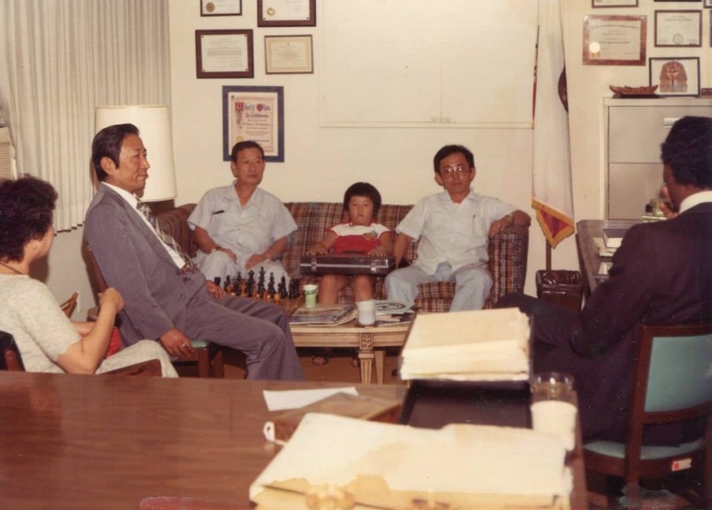 University leaders seated in an office lined with framed certificates