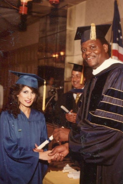 Graduate shaking hands with a university officer while receiving a diploma