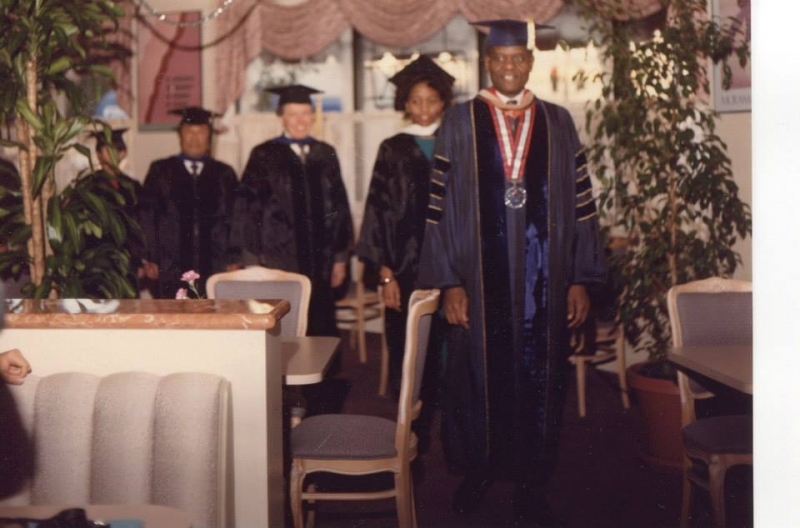 Academic processional led by a university officer wearing a presidential medallion
