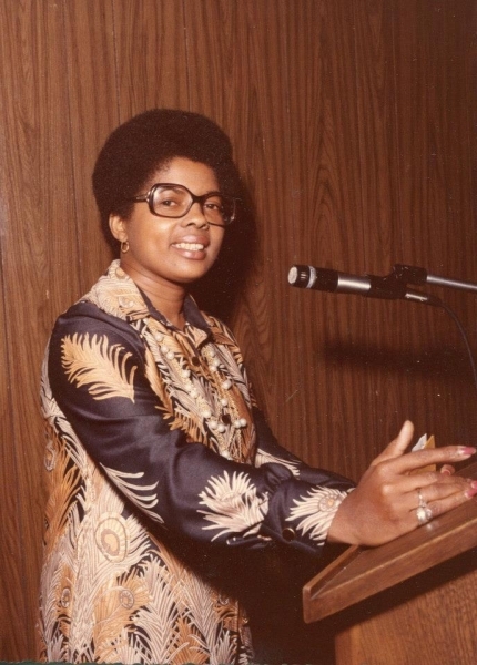 Speaker addressing the audience from a lectern with a microphone